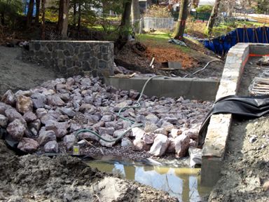 Rip rap stone installation at auxiliary spillway